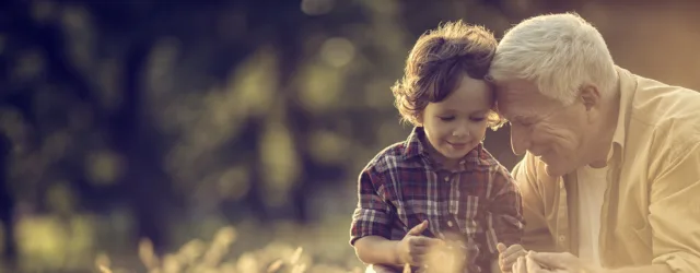 Grandfather and grandson in field