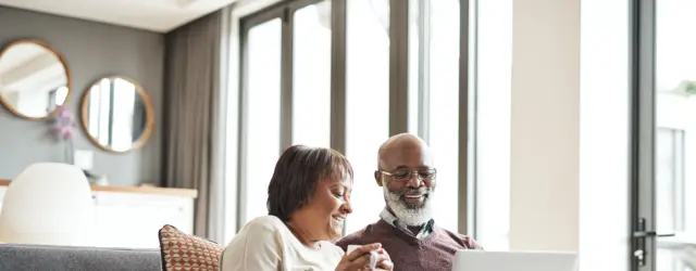 Couple sitting on couch looking at computer